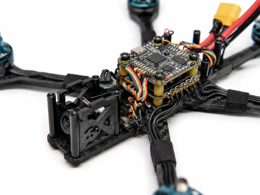 Flight controller mounted on top of a 4-in-1 ESC forming a stack inside a 5-inch FPV drone frame